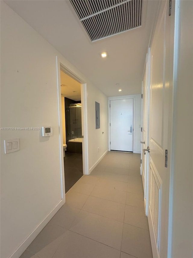 hallway featuring light tile patterned floors and electric panel