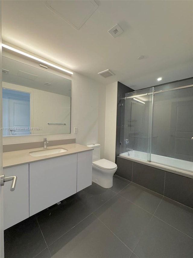 full bathroom with tile patterned flooring, vanity, toilet, and shower / bath combination with glass door