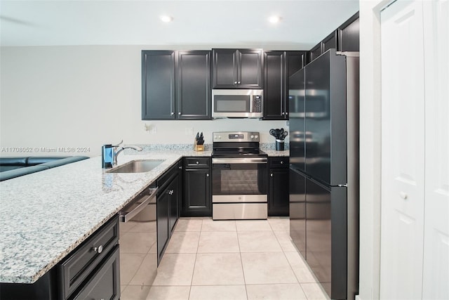 kitchen featuring light stone counters, light tile patterned floors, sink, and appliances with stainless steel finishes