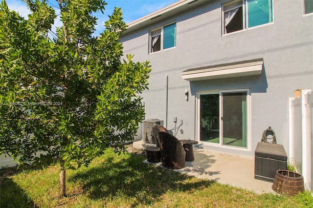 back of house featuring a lawn, a patio area, and central air condition unit