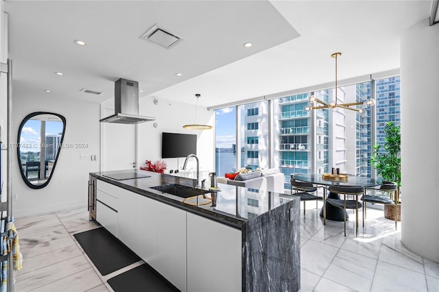 kitchen with white cabinetry, sink, a spacious island, pendant lighting, and extractor fan