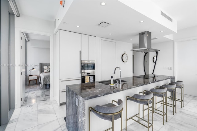 kitchen featuring double oven, dark stone countertops, sink, and white cabinets