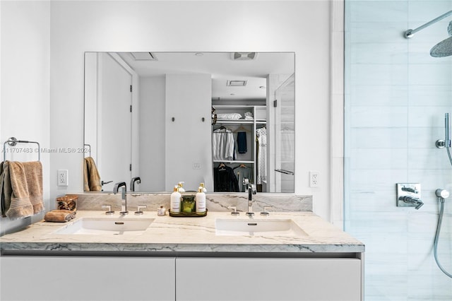 bathroom with tiled shower and vanity