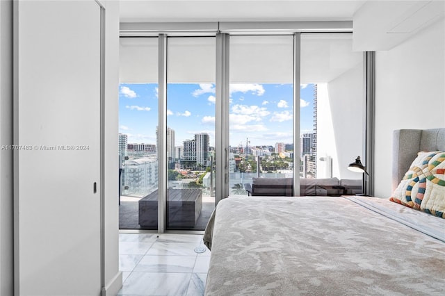 bedroom with access to outside, multiple windows, and a wall of windows