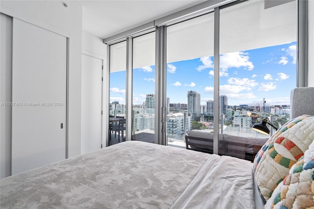 bedroom with access to exterior and a wall of windows