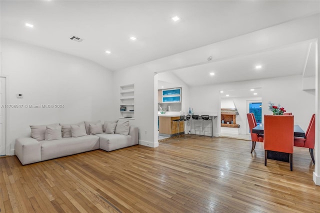 living room with vaulted ceiling and light wood-type flooring