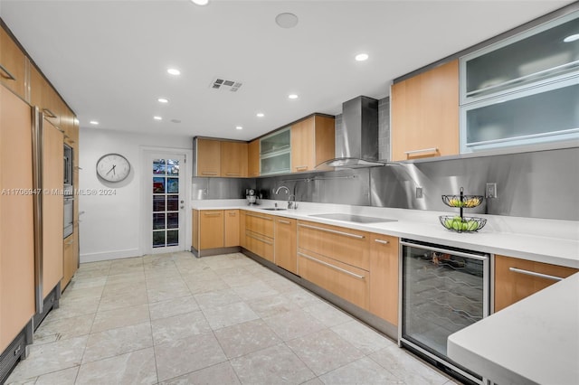 kitchen with backsplash, black electric cooktop, sink, wall chimney range hood, and wine cooler