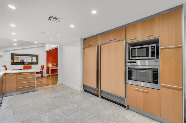 kitchen with light tile patterned floors and stainless steel appliances