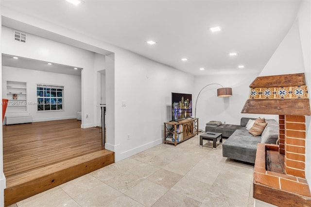 living room featuring light hardwood / wood-style floors and a brick fireplace