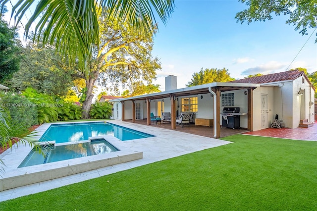 rear view of property with a swimming pool with hot tub, an outdoor living space, a patio area, and a yard