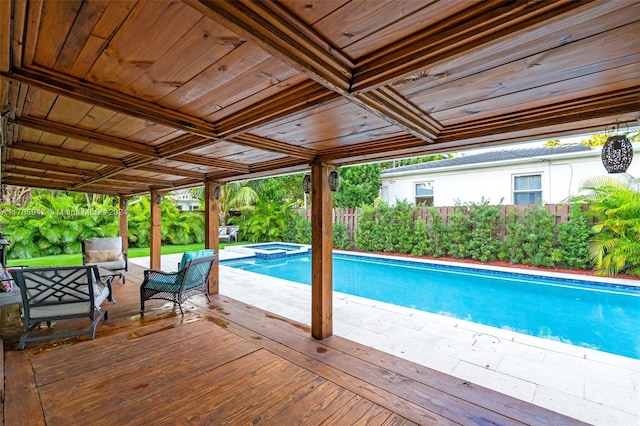 view of swimming pool featuring a wooden deck and an in ground hot tub