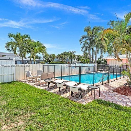 view of swimming pool featuring a patio area and a yard