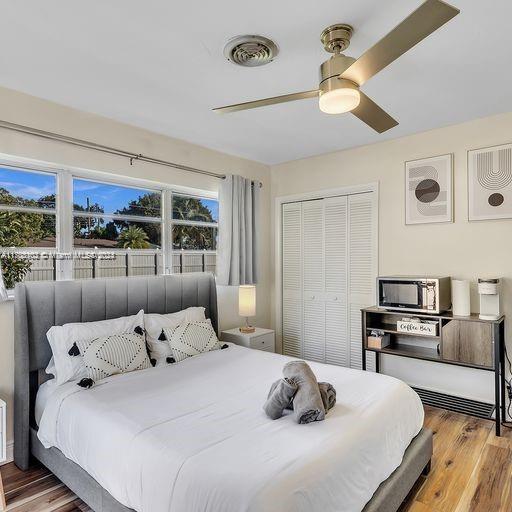 bedroom with ceiling fan, a closet, and wood-type flooring