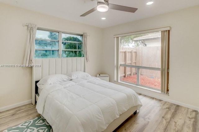 bedroom featuring multiple windows, ceiling fan, and light hardwood / wood-style flooring