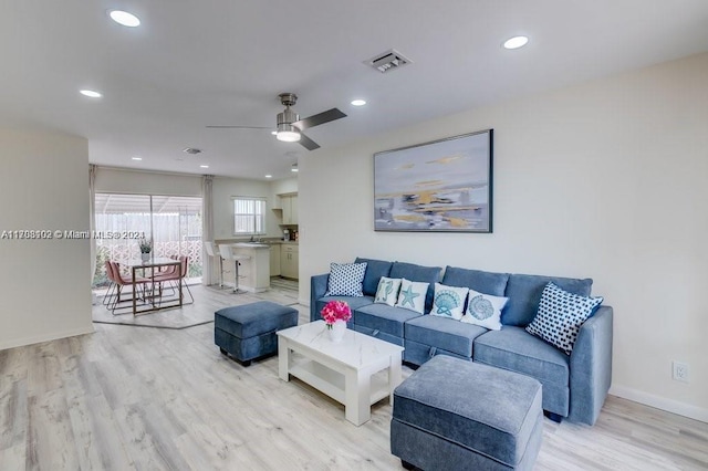 living room featuring ceiling fan and light hardwood / wood-style flooring