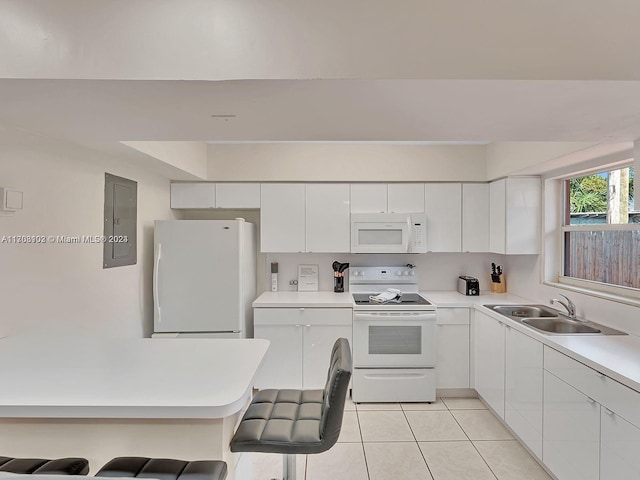 kitchen featuring a kitchen breakfast bar, white appliances, sink, white cabinets, and electric panel