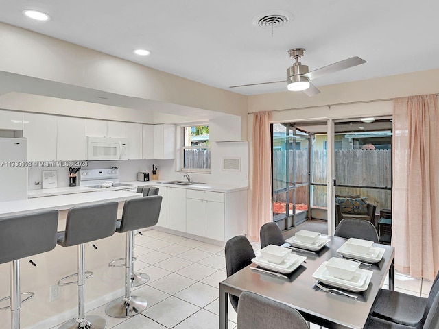 kitchen featuring white cabinetry, sink, light tile patterned flooring, and white appliances