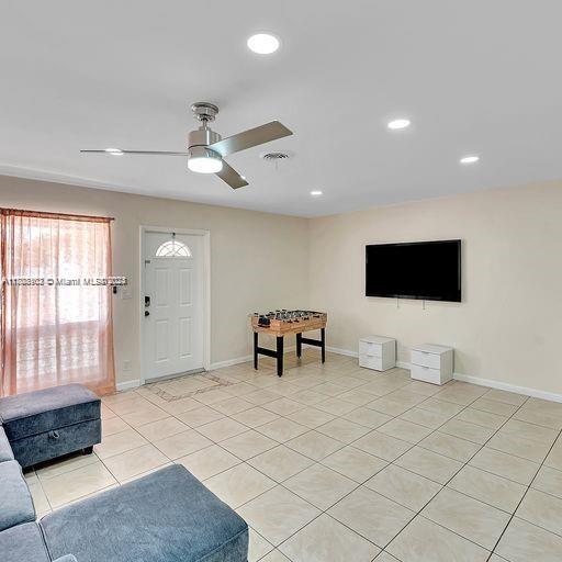 tiled living room with ceiling fan