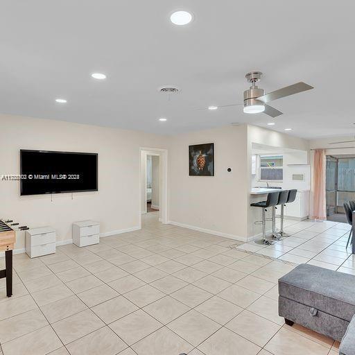 tiled living room featuring ceiling fan