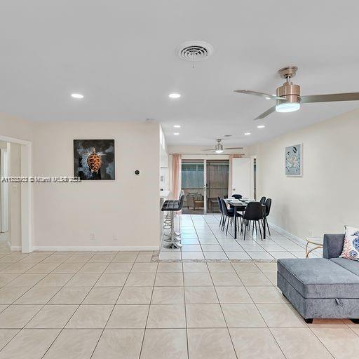 living room with ceiling fan and light tile patterned floors