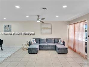 living room with ceiling fan and light tile patterned flooring