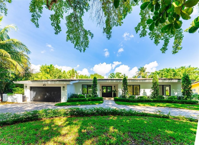 single story home featuring a garage and a front lawn