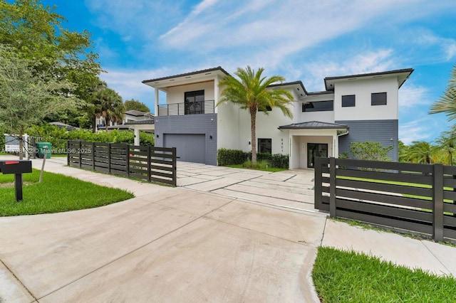 6401 SW 84th St, South Miami, FL 33143 - contemporary home featuring a balcony, a fenced front yard, concrete driveway, a garage, and stucco siding