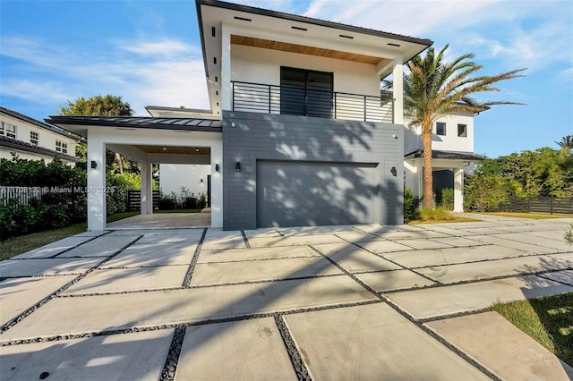 6401 SW 84th St, South Miami, FL 33143 - view of front of home with a balcony, an attached garage, a standing seam roof, concrete driveway, and stucco siding