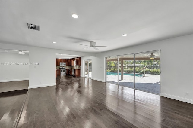 unfurnished living room with ceiling fan and dark wood-type flooring