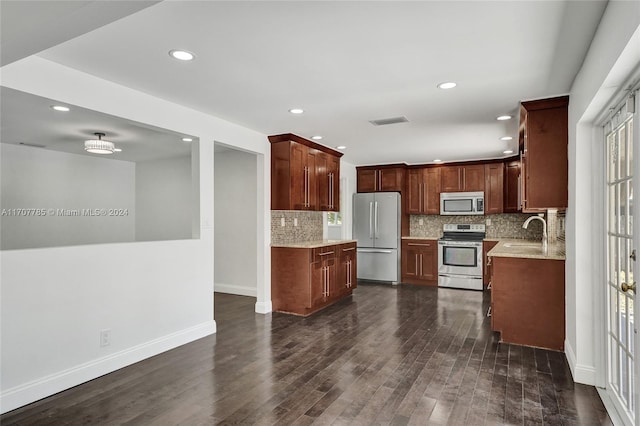 kitchen with tasteful backsplash, dark hardwood / wood-style flooring, stainless steel appliances, and sink