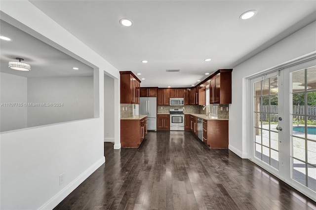 kitchen with appliances with stainless steel finishes, tasteful backsplash, french doors, and dark wood-type flooring