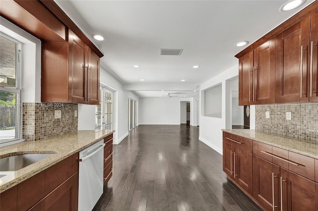 kitchen featuring dishwasher, dark hardwood / wood-style floors, decorative backsplash, and light stone countertops