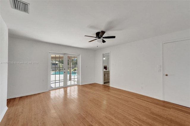 empty room featuring ceiling fan, french doors, and light hardwood / wood-style flooring