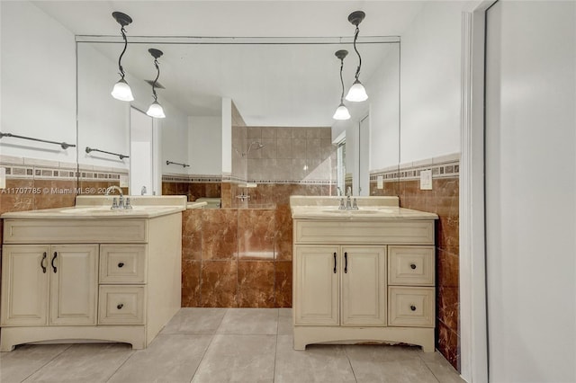 bathroom featuring tile patterned flooring, vanity, a shower, and tile walls