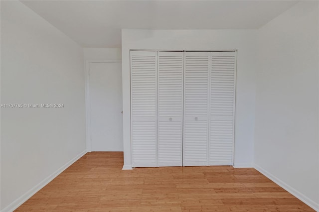 unfurnished bedroom with a closet and light hardwood / wood-style flooring