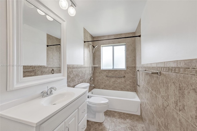 full bathroom featuring tiled shower / bath combo, tile patterned flooring, toilet, vanity, and tile walls