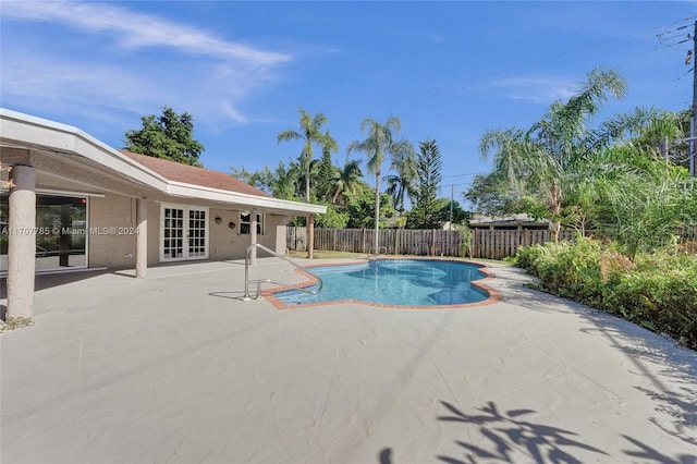 view of swimming pool featuring a patio and french doors