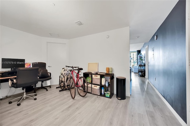 home office with light hardwood / wood-style floors