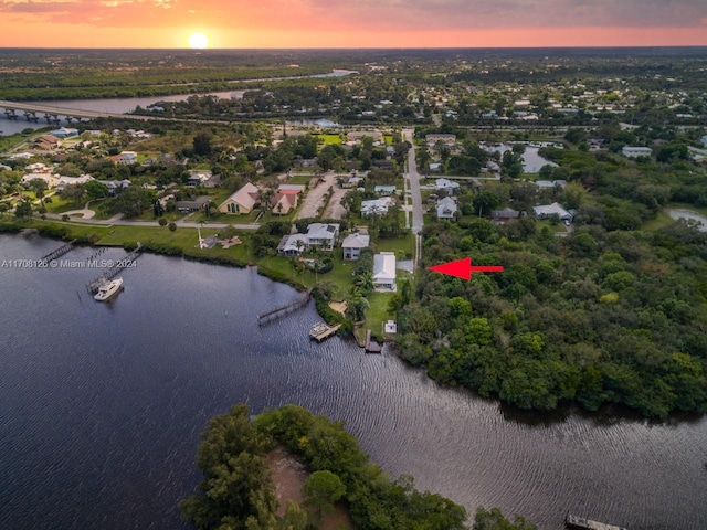 aerial view at dusk featuring a water view