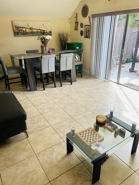 dining room with tile patterned flooring and vaulted ceiling