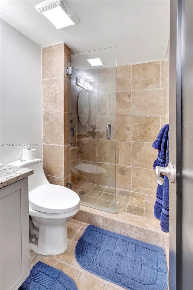 bathroom featuring vanity, toilet, and an enclosed shower