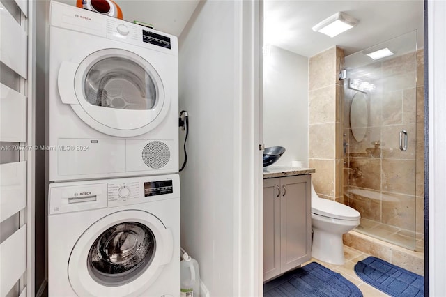 washroom featuring tile patterned flooring and stacked washer / dryer