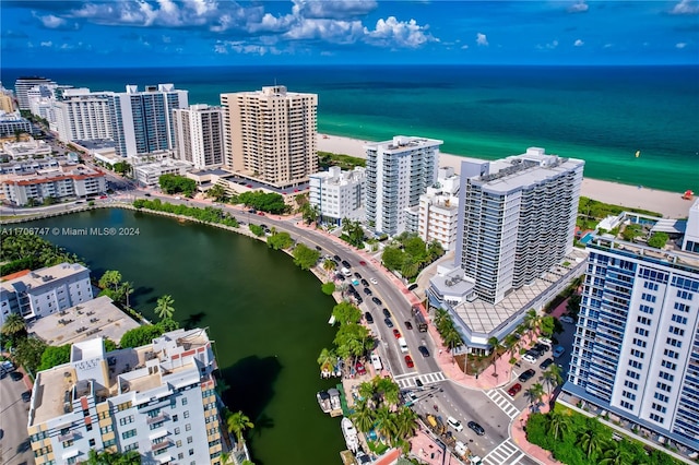 birds eye view of property with a water view and a beach view