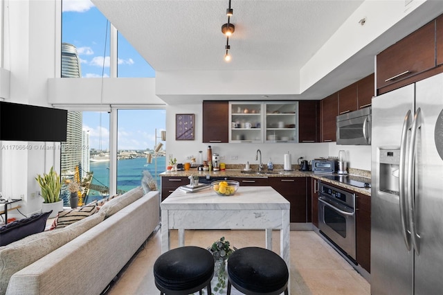 kitchen featuring dark brown cabinetry, sink, stainless steel appliances, and a textured ceiling