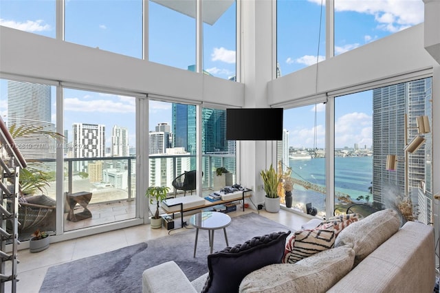 tiled living room featuring plenty of natural light and a water view