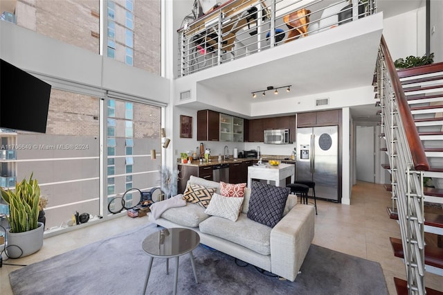 living room featuring a towering ceiling and sink