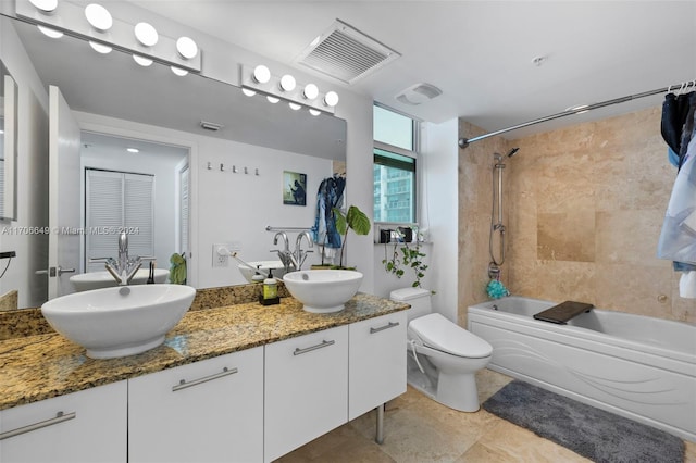 full bathroom with tile patterned flooring, toilet, vanity, and tiled shower / bath