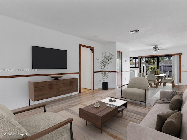 living room with light hardwood / wood-style floors and ceiling fan