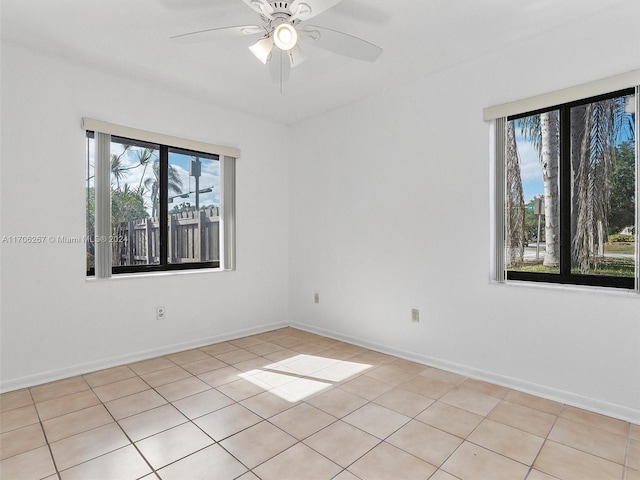 tiled spare room with ceiling fan and a healthy amount of sunlight