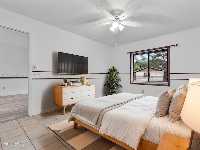 bedroom with ceiling fan and light tile patterned flooring